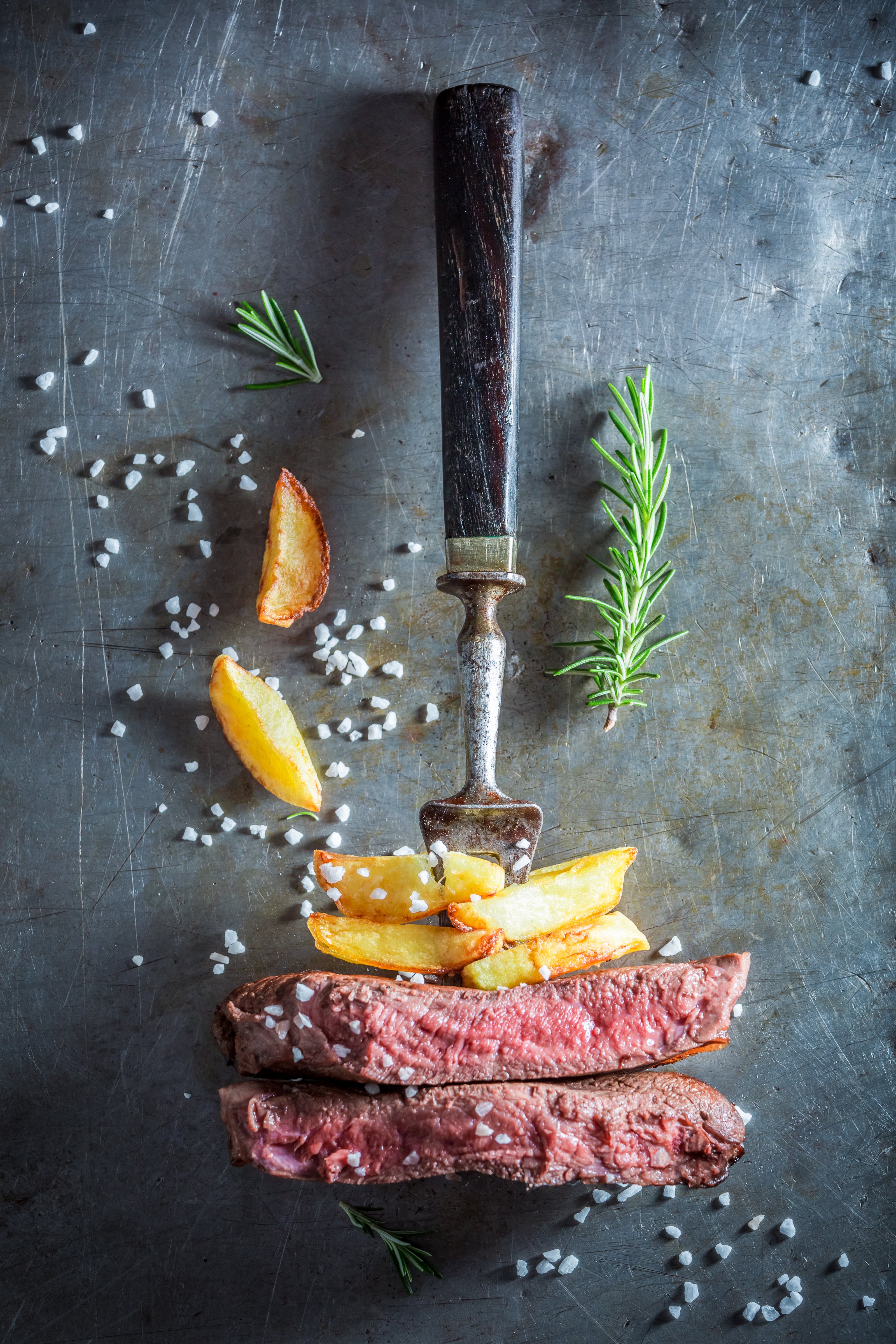 Cooked Beef & fried potatoes on a fork